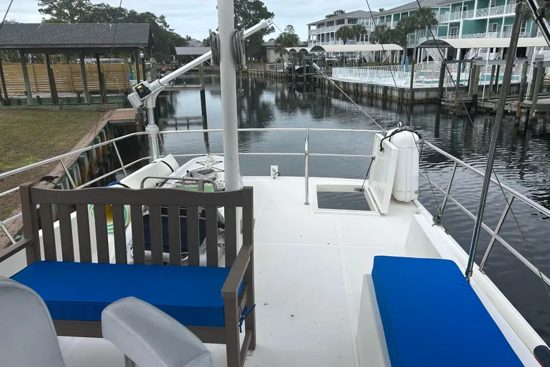 Slide: The Image of 2006 Mariner Orient boat docked, featuring blue cushioned seating and a serene waterfront view. - 14