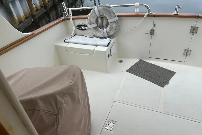 Slide: The Image of 2006 Mariner Orient boat deck with seating, life preserver, and covered equipment. - 16