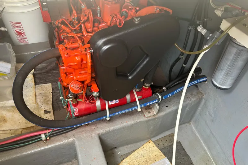 Slide: The Image of 2006 Mariner Orient engine with red components and hoses in a boat compartment. - 24