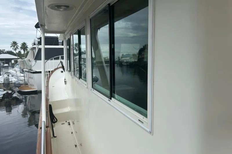 Slide: The Image of 2006 Mariner Orient yacht docked, showcasing side view with windows and marina background. - 25