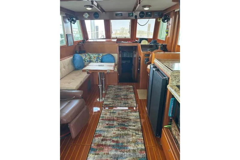 Slide: The Image of 2006 Mariner Orient boat interior with plush seating, wooden flooring, and modern amenities. - 5