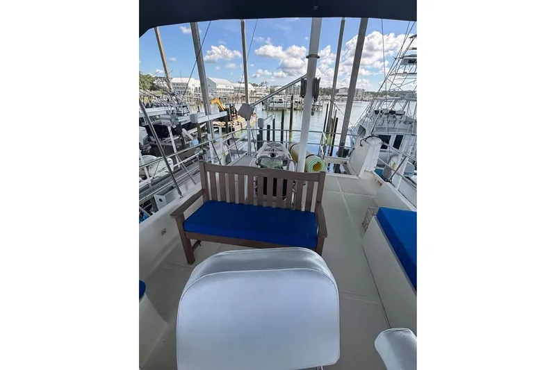 Slide: The Image of 2006 Mariner Orient yacht deck with blue cushioned seating, docked at a marina. - 6