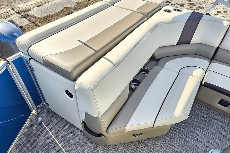 Slide: The Image of 2026 SunCatcher Select 20C boat interior with beige and brown seating, cup holders, and textured flooring. - 12