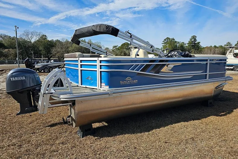 Slide: The Image of 2026 SunCatcher Select 20C pontoon boat with Yamaha motor, parked on grass. - 3