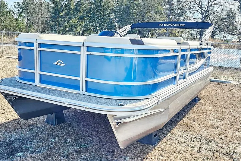 Slide: The Image of 2026 SunCatcher Select 20C pontoon boat, blue exterior, parked on grass. - 5