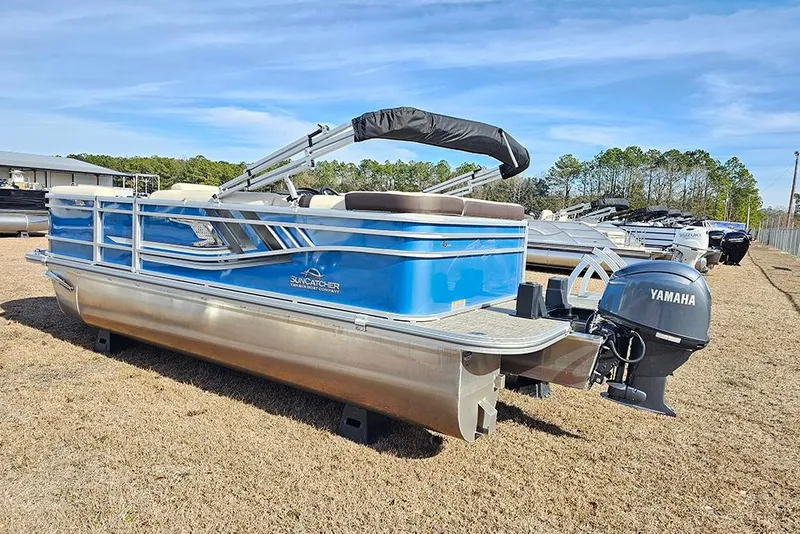 Slide: The Image of 2026 SunCatcher Select 20C pontoon boat with Yamaha motor, parked on grass. - 7