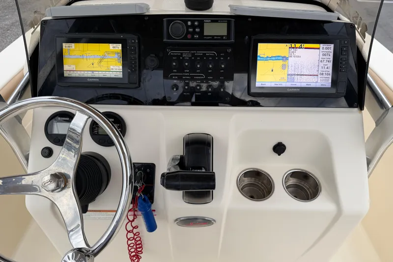Slide: The Image of 2020 Scout 215 XSF boat dashboard with Garmin navigation displays and steering wheel. - 12