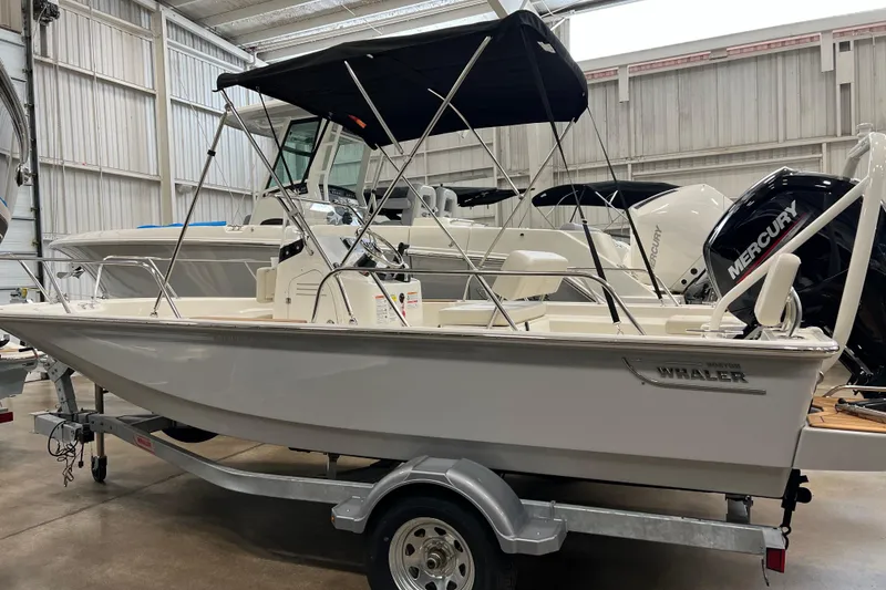 Slide: The Image of 2026 Boston Whaler 170 Montauk boat on trailer in indoor showroom. - 2