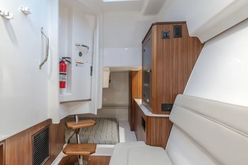 Slide: The Image of Interior of a 2018 Pursuit boat featuring wood accents and seating area. - 19