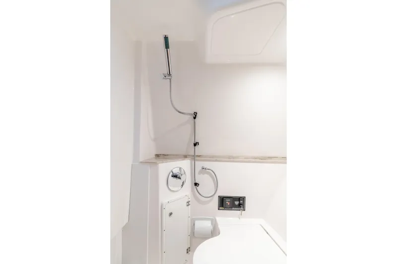 Slide: The Image of Compact 2018 Pursuit boat bathroom with showerhead and modern fixtures. - 21