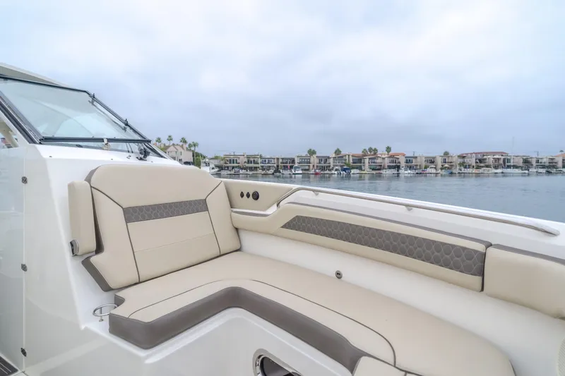 Slide: The Image of Luxurious 2018 Pursuit boat interior with beige seating, overlooking waterfront homes. - 25