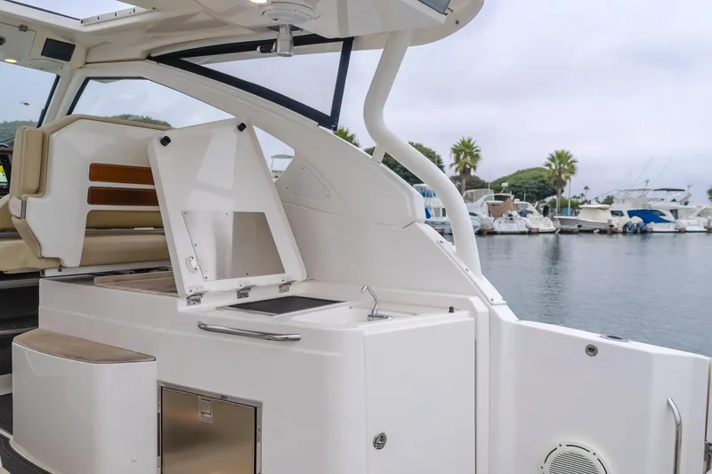 Slide: The Image of 2018 Pursuit boat interior with open storage, docked at marina with palm trees. - 31