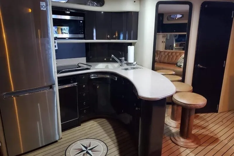 Slide: The Image of Luxurious 1999 Sea Ray 630 Sundancer yacht interior with modern kitchen and seating area. - 6
