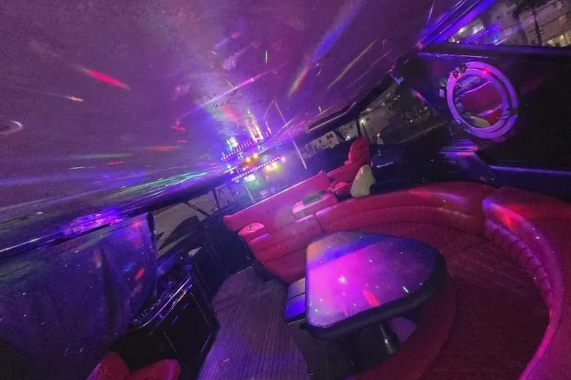 Slide: The Image of Luxurious 1999 Sea Ray 630 Sundancer interior with vibrant lighting and plush red seating. - 9