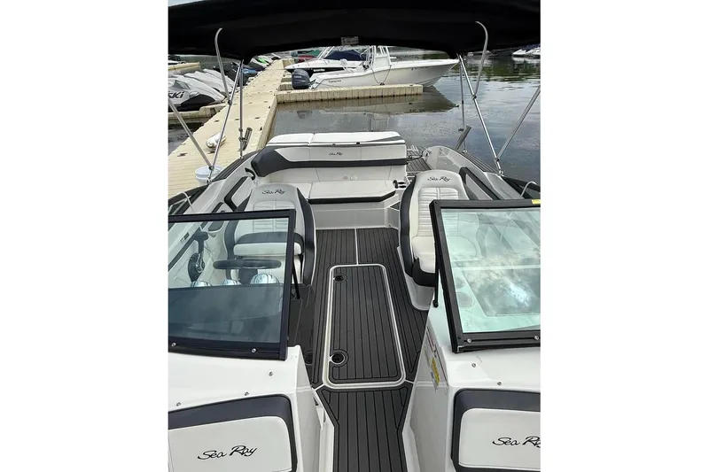 Slide: The Image of 2018 Sea Ray SPX 210 boat interior with seating and dashboard, docked at marina. - 6