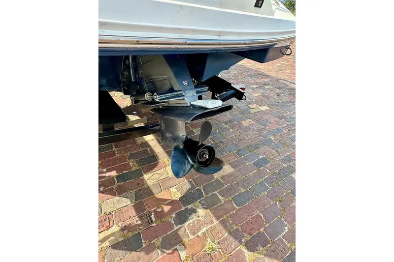Slide: The Image of Rear view of a 2012 Regal 2100 Bowrider boat propeller on brick pavement. - 10