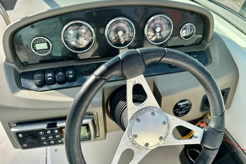 Slide: The Image of Dashboard of a 2012 Regal 2100 Bowrider boat with steering wheel and gauges. - 22