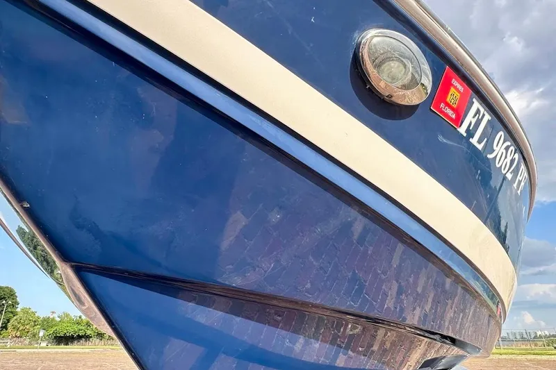 Slide: The Image of 2012 Regal 2100 Bowrider boat with Florida registration, blue hull, close-up view. - 9