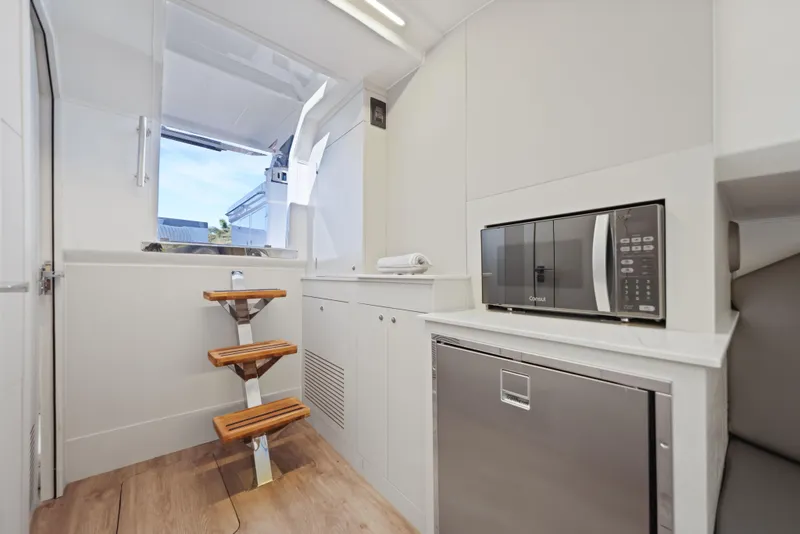 Slide: The Image of Interior of 2025 Valiatt 380 Bowrider with microwave, fridge, and wooden steps. - 18