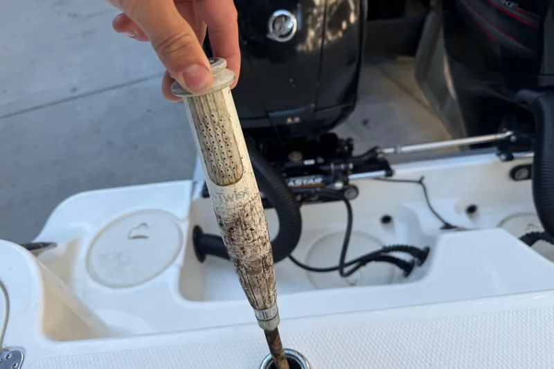 Slide: The Image of Hand holding a dirty filter on a 2017 Mako 234 Center Console boat. - 21