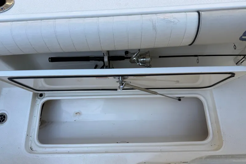 Slide: The Image of 2017 Mako 234 Center Console boat with open storage compartment and fishing rod. - 24