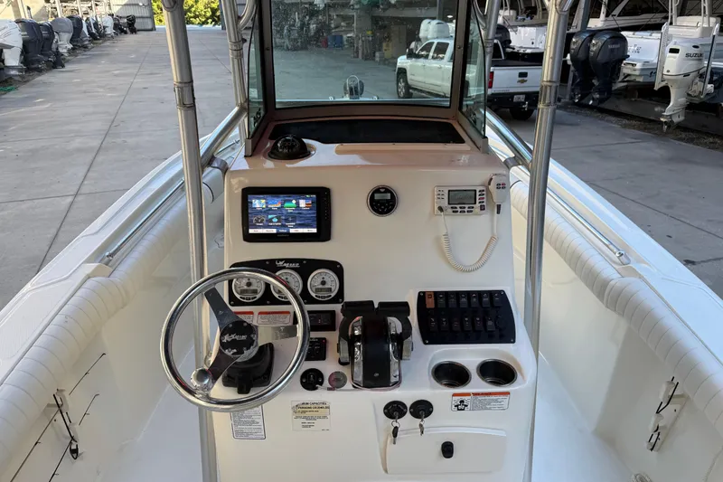 Slide: The Image of 2017 Mako 234 Center Console boat dashboard with steering wheel and navigation controls. - 34