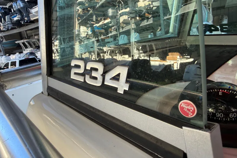 Slide: The Image of 2017 Mako 234 Center Console boat with reflective window and Taylor Made sticker. - 42