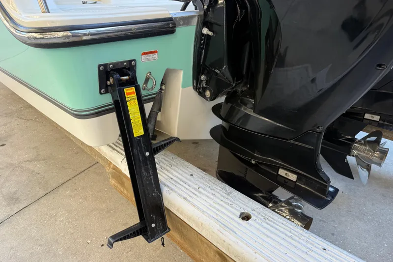 Slide: The Image of 2017 Mako 234 Center Console boat with dual outboard motors and a black support bracket. - 5