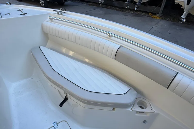Slide: The Image of 2017 Mako 234 Center Console boat interior with cushioned seating and cup holder. - 53