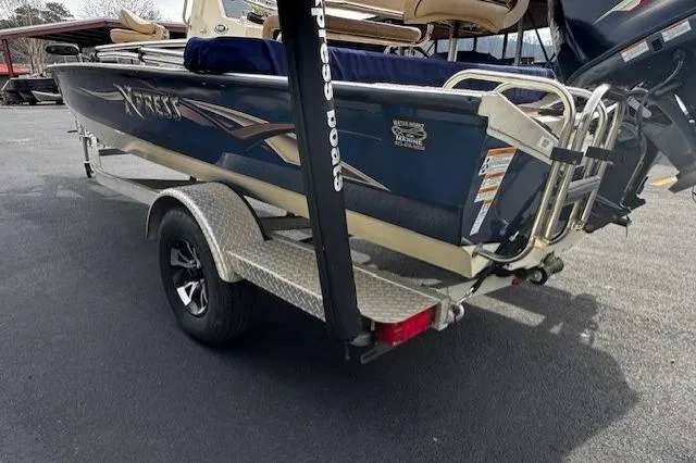 Slide: The Image of 2018 Xpress H20B Bay boat on trailer, rear view, parked outdoors. - 2