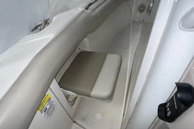 Slide: The Image of 2020 Boston Whaler 250 Outrage interior seating area with cushioned seat and storage. - 16