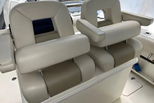 Slide: The Image of 2020 Boston Whaler 250 Outrage boat seats, featuring beige cushioned armrests and backrests. - 20