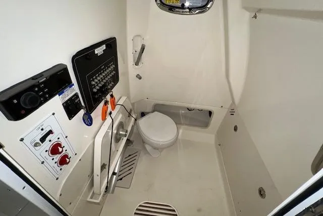 Slide: The Image of 2020 Boston Whaler 250 Outrage boat interior with toilet and control panel. - 22