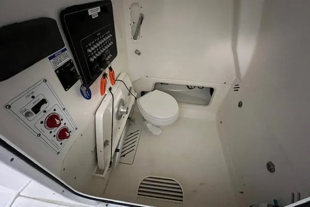 Slide: The Image of 2020 Boston Whaler 250 Outrage interior with marine toilet and control panel. - 24