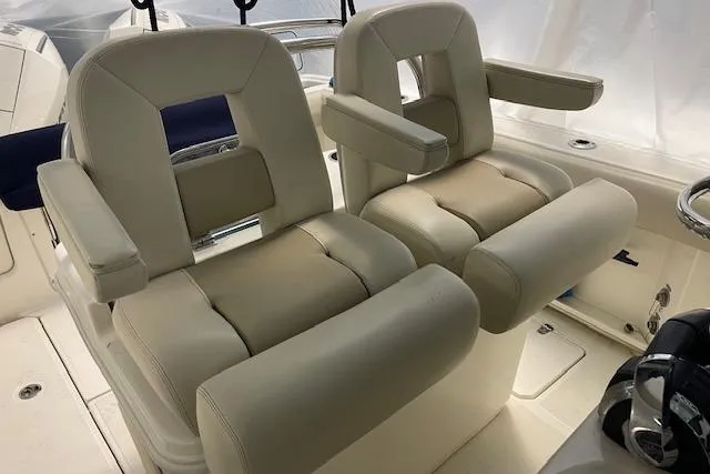 Slide: The Image of 2020 Boston Whaler 250 Outrage boat seats, featuring plush beige upholstery and armrests. - 31