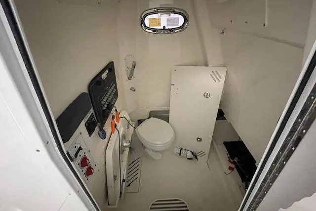 Slide: The Image of 2020 Boston Whaler 250 Outrage interior cabin with toilet and control panel. - 35