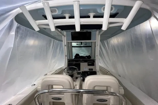 Slide: The Image of 2020 Boston Whaler 250 Outrage boat interior with helm and seating under protective cover. - 4