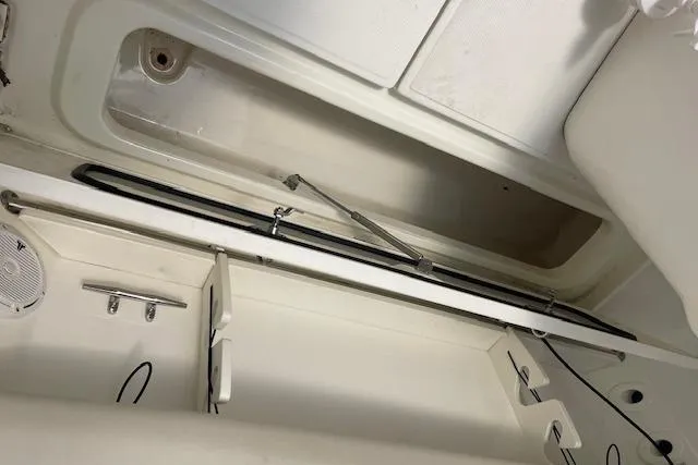 Slide: The Image of 2020 Boston Whaler 250 Outrage interior storage compartment with rod holders and speaker. - 46