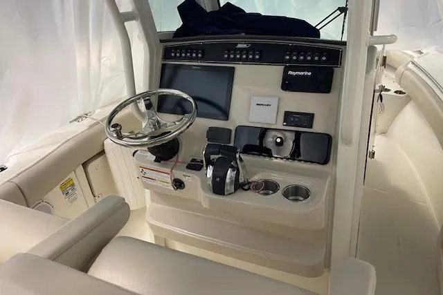 Slide: The Image of 2020 Boston Whaler 250 Outrage helm with steering wheel and navigation controls. - 50