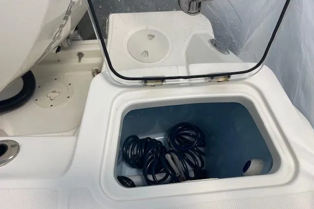 Slide: The Image of Storage compartment on a 2020 Boston Whaler 250 Outrage boat, containing coiled cables. - 56