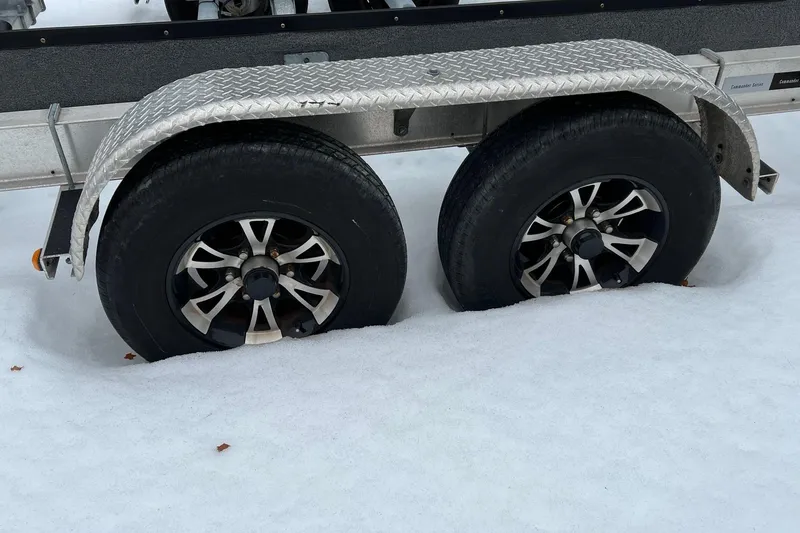 Slide: The Image of Trailer wheels of a 2020 Boston Whaler 250 Outrage, partially buried in snow. - 62
