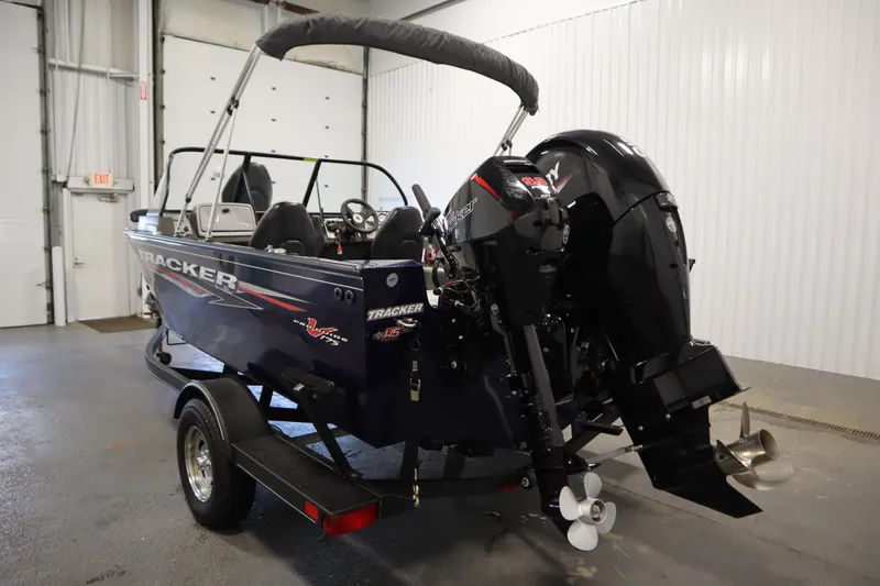Slide: The Image of 2023 Tracker Pro Guide V-175 WT boat in garage, featuring powerful outboard motor. - 7