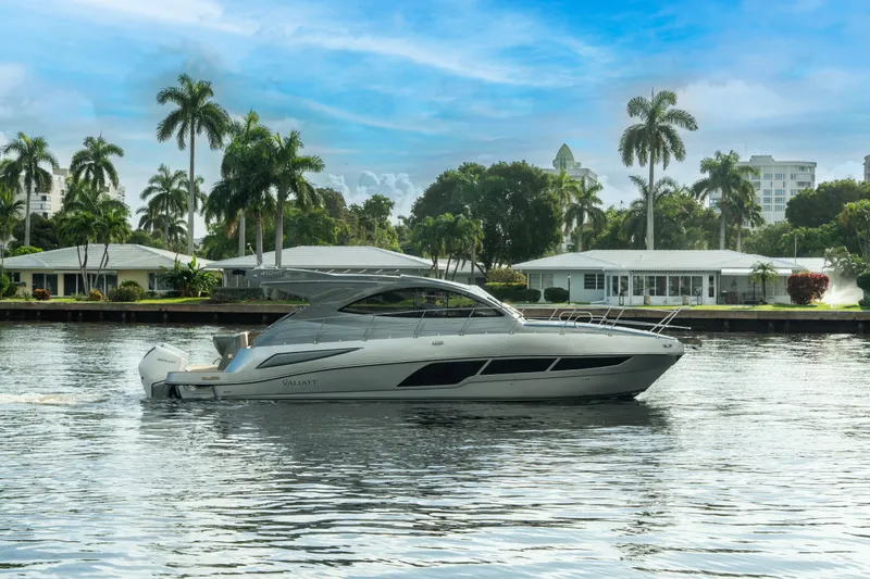Slide: The Image of 2025 Valiatt 410HT luxury yacht cruising on a scenic waterway with palm trees. - 2