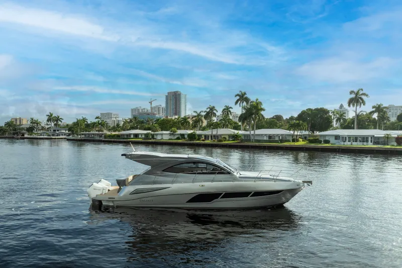 Slide: The Image of 2025 Valiatt 410HT yacht cruising on a serene waterway with cityscape backdrop. - 8