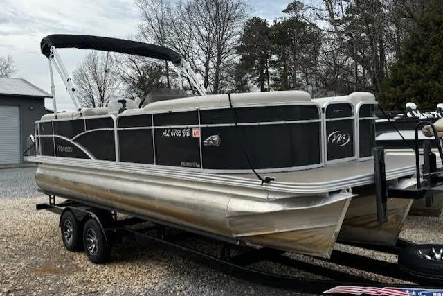 The Image of 2019 Manitou 23 Aurora LE Standard pontoon boat on trailer, parked outdoors. - 1