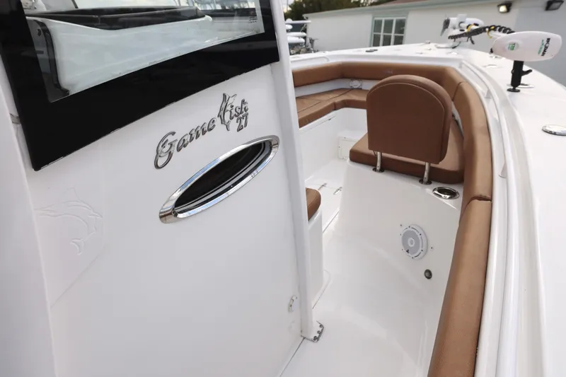 Slide: The Image of 2022 Sea Hunt Gamefish 27 Forward Seating boat interior with brown cushions and sleek design. - 14