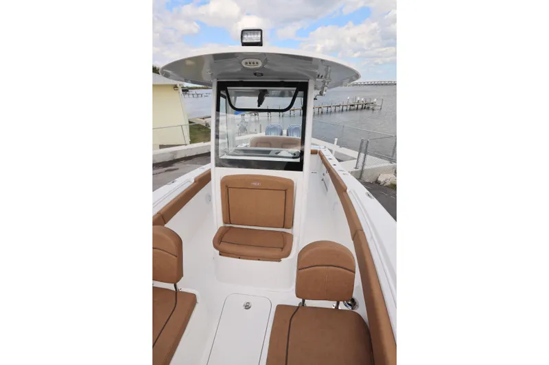 Slide: The Image of 2022 Sea Hunt Gamefish 27 Forward Seating boat with brown cushions, dockside view. - 24