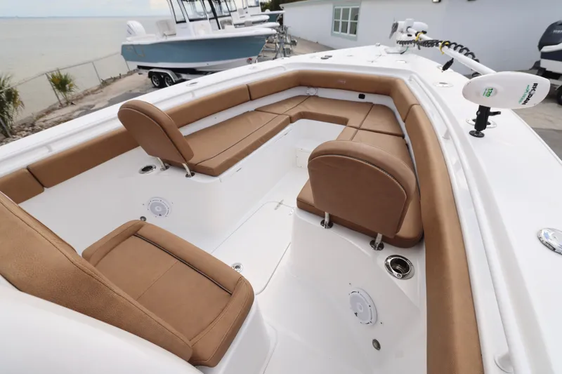 Slide: The Image of 2022 Sea Hunt Gamefish 27 Forward Seating with tan cushions, docked by the water. - 5