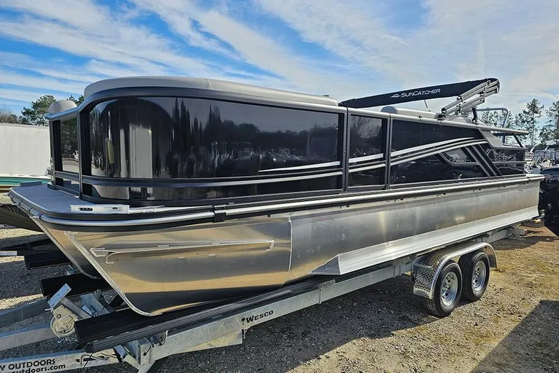 The Image of 2026 SunCatcher Fusion 324SS pontoon boat on trailer, sleek design, outdoor setting. - 1