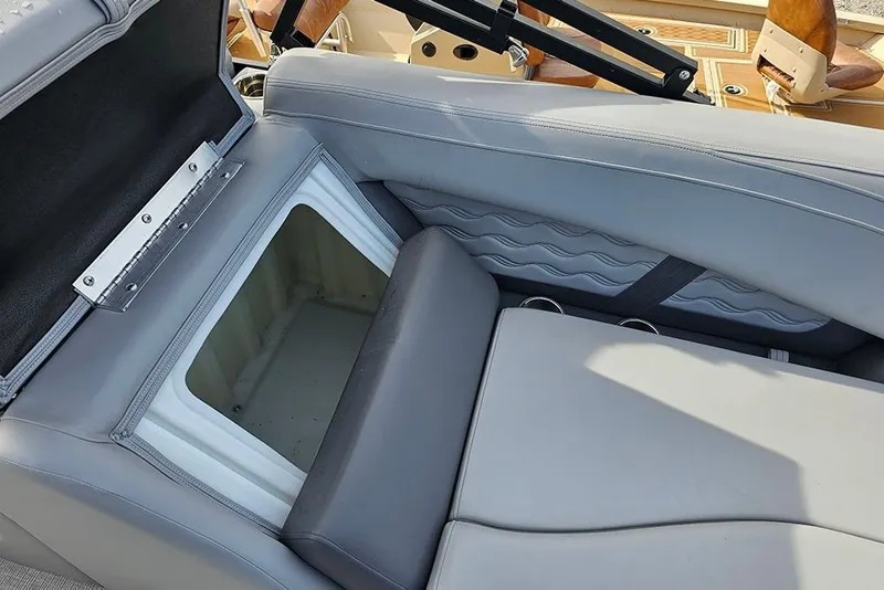 Slide: The Image of Open storage compartment in SunCatcher Fusion 324SS boat, 2026 model, with gray seating. - 19
